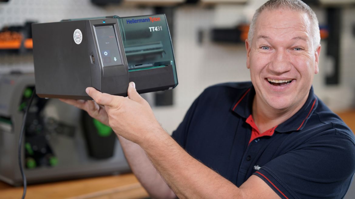 Man holds a thermal transfer printer TT431 in his hands
