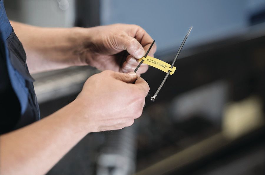 Worker applies Tiptag cable marker with cable tie