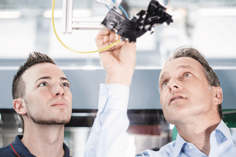 A production engineer and component designer look at details of an injection moulded plastic automotive component