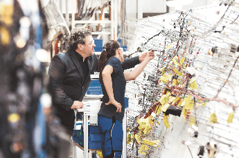Two people discussing a solution for a vehicle component