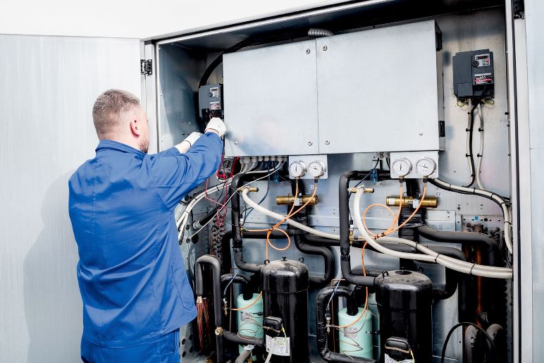 Man working on wiring heat pump
