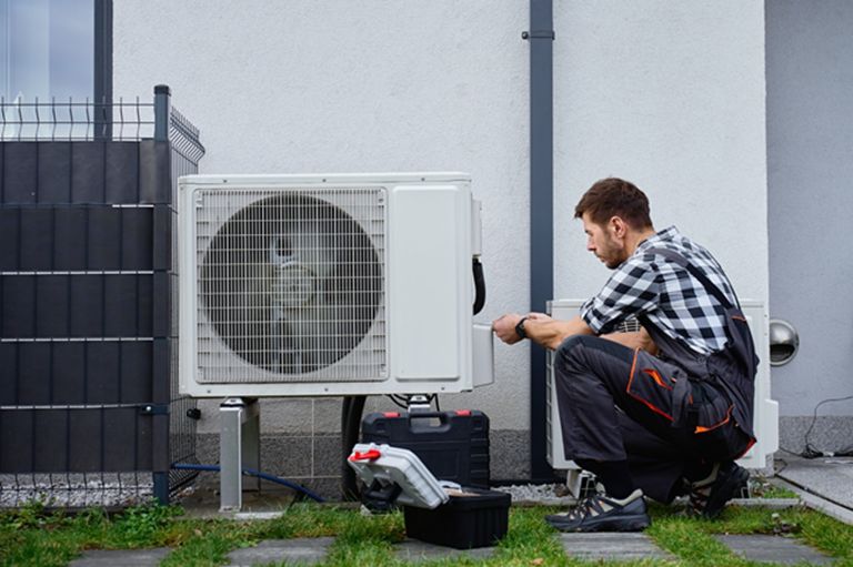 Man working on wiring heat pump