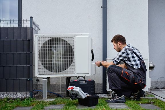 Man working on wiring heat pump