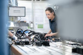 Worker at cable assembly in automotive production line