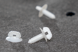 This push-in carpet fastener plug securely holds the floor carpet in place in the vehicle interior.