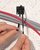 2. Um Kabel hinzuzufügen oder zu entfernen, die Grifflasche durch leichtes Vorziehen wieder lösen.